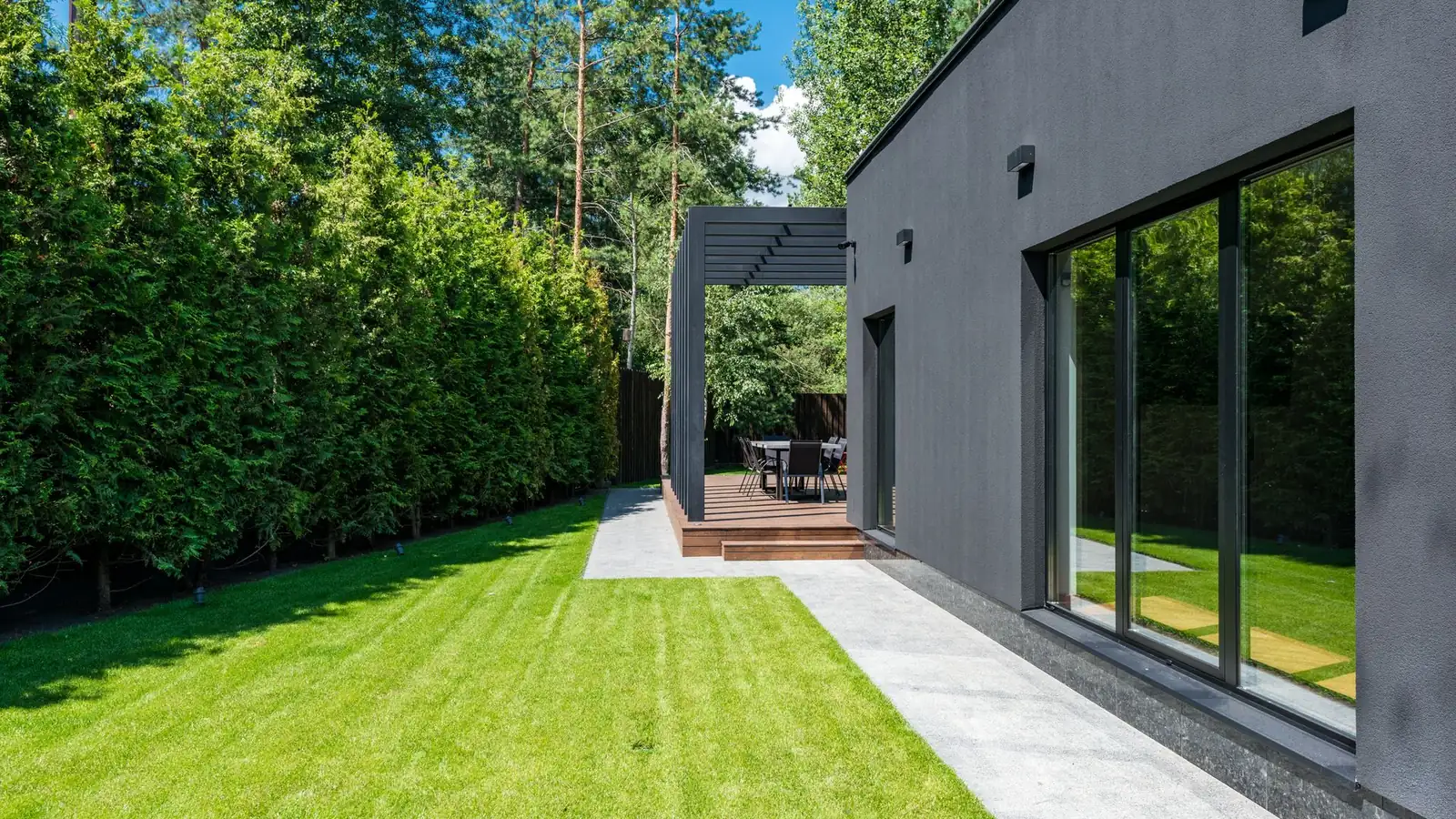 Neu angelegter Garten mit Rollrasen und Hecke an einem modernen Haus