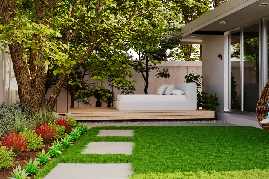 Angelegter Garten mit Sitzbereich, Beeten und Trittplatten im Rasen
