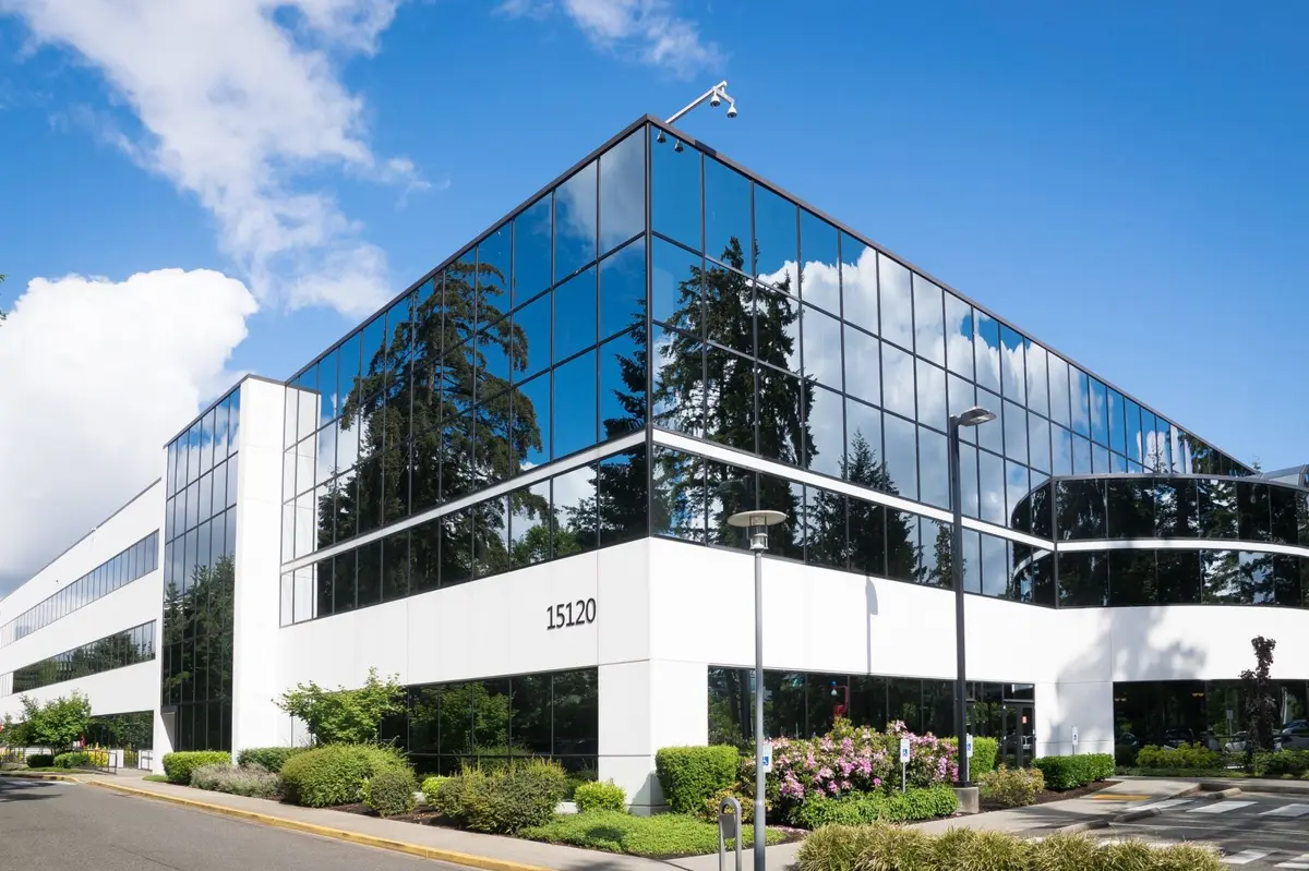 Bürogebäude mit Glasfassade und gepflegten Pflanzbeeten